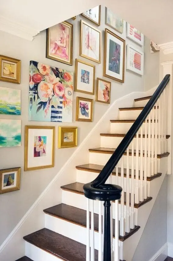 Gallery wall on stairway with assorted paintings