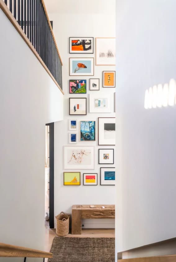 Modern staircase lined with an eclectic art collection