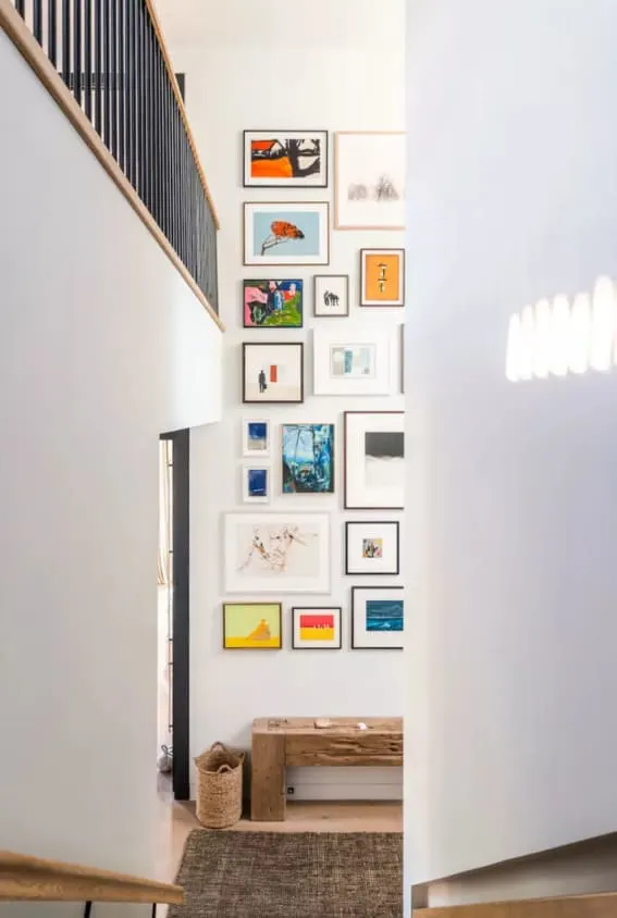 Modern staircase lined with an eclectic art collection