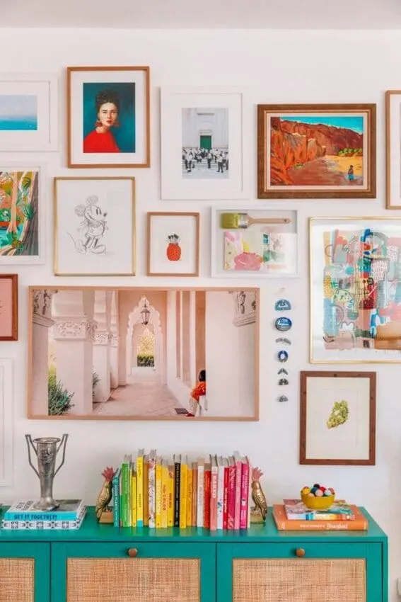 Whimsical art gallery above a turquoise credenza