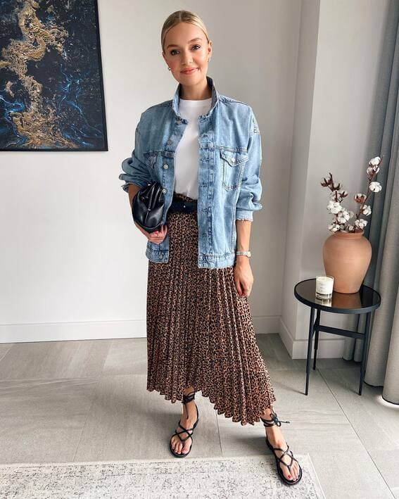 A woman wearing an denim jacket, paired with the leopard print skirt 