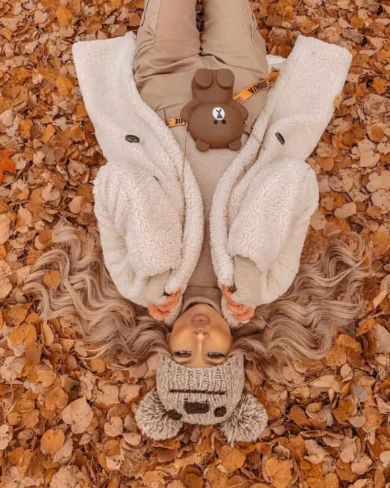 Woman in an adorable fall outfit with a teddy coat and knit beanie. 