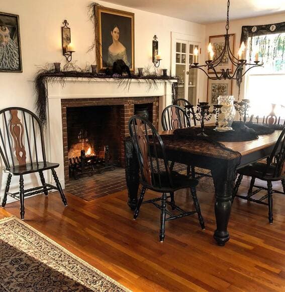 Gothic-inspired dining room with vintage portraits and black lace decor. 