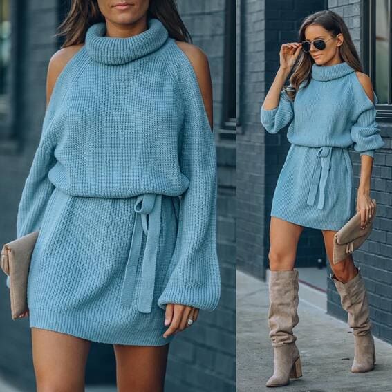 A woman is wearing the blue cold-shoulder turtleneck dress and knee-high boots.