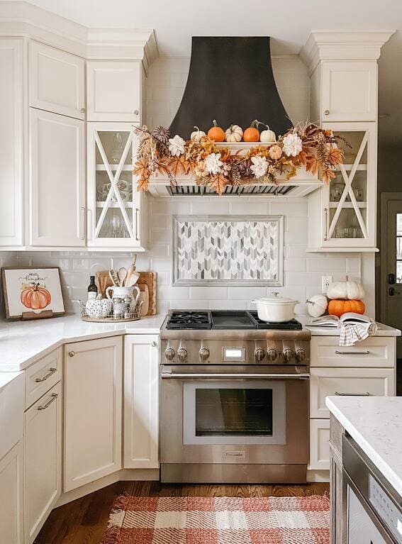 A charming fall garland draped over the kitchen range hood, featuring pumpkins, autumn leaves, and soft florals, adding a seasonal touch to the heart of the home. 