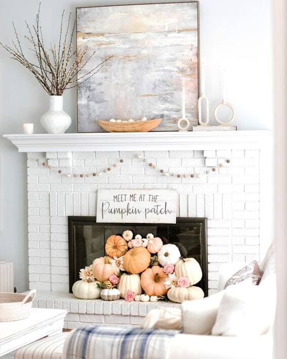 Neutral fall mantel with pastel pumpkins and simple decor accents. 