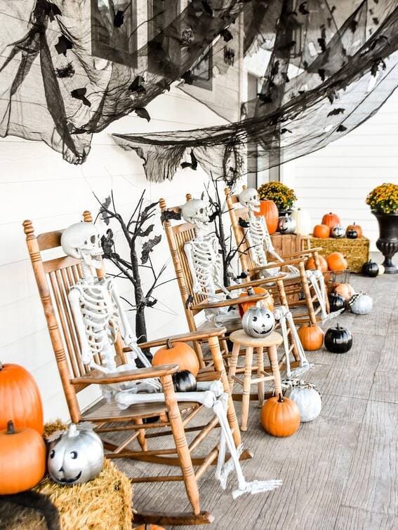 This porch delivers a spooky yet charming Halloween look, with skeletons comfortably lounging in wooden rocking chairs as if waiting to greet visitors.