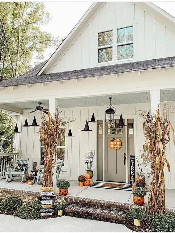 This front porch is both charming and spooky, featuring a row of floating witch hats that seem to hover mid-air, creating a magical atmosphere. 