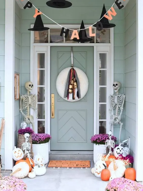 This Halloween porch design is equal parts fun and spooky, with a cheerful banner of floating witch hats that immediately sets a magical tone. 