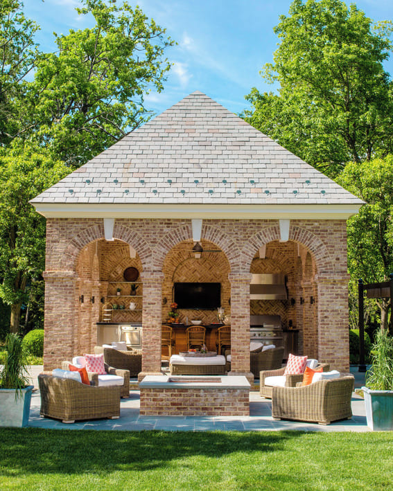 Beautiful brick pavilion that has an outdoor kitchen as well as a seating around the fire pit. 