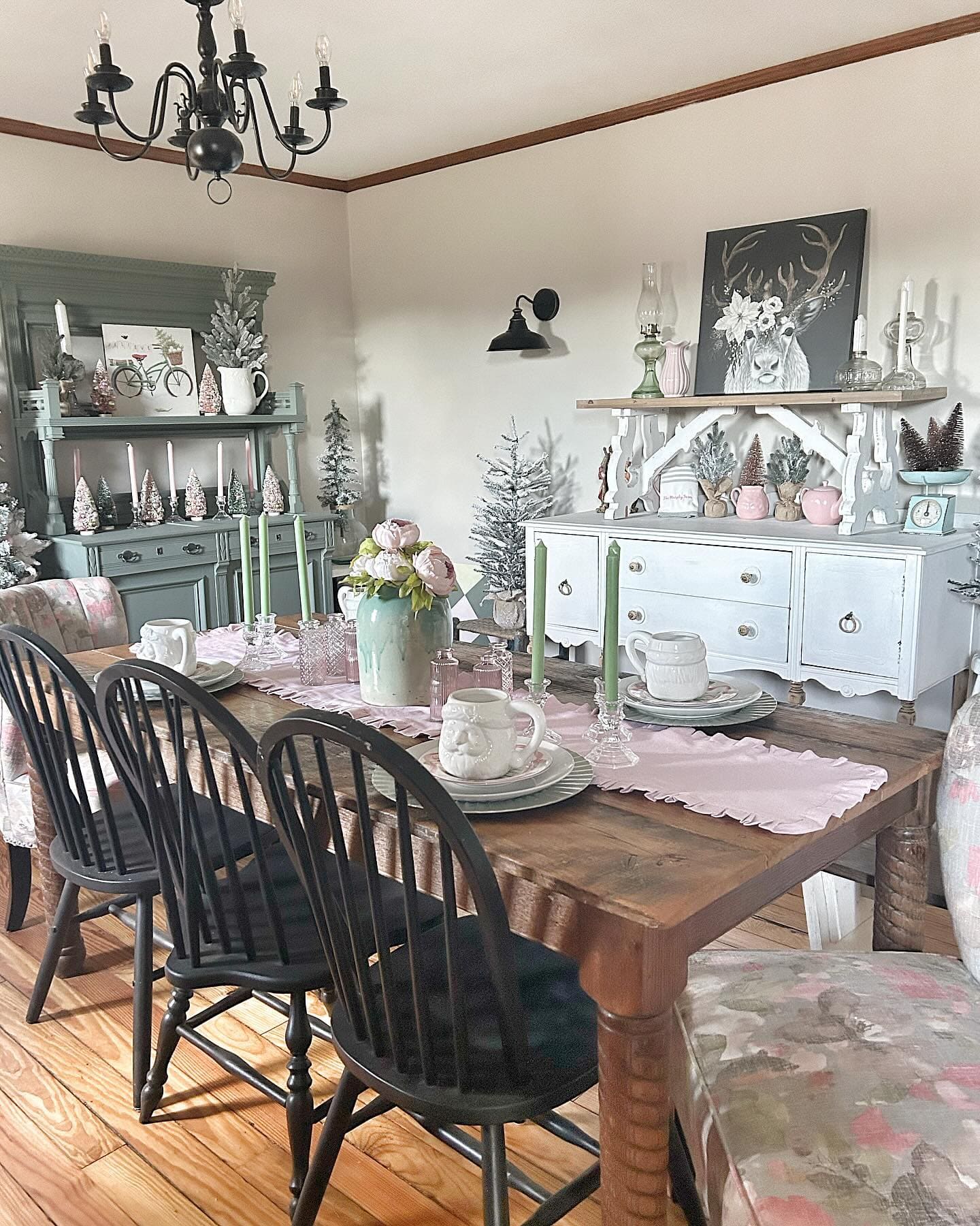 This image is a great idea for cozy farmhouse dining inspiration, featuring a warm wooden table, soft pastel decor, and classic black chairs for a charming vintage look.Farmhouse dining room decor inspiration by @themurphyfarm / Instagram