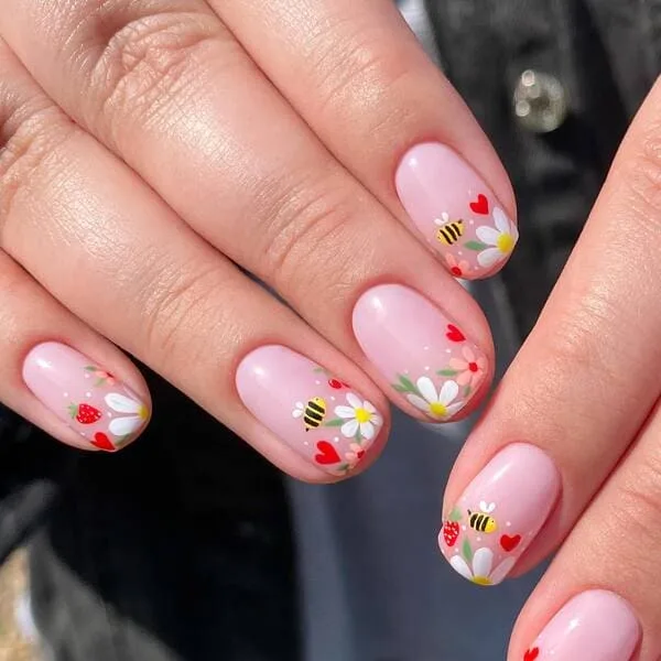 spring nails with bees, daisies, hearts, and strawberries